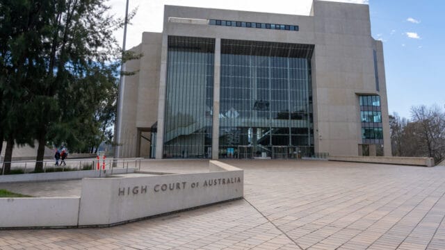 Modernist concrete and glass high court building under a clear sky