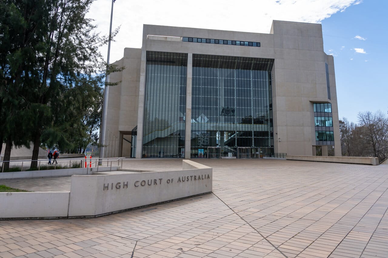 Modernist concrete and glass high court building under a clear sky