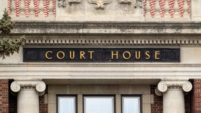 Stone courthouse facade with carved Court House lettering above classical columns