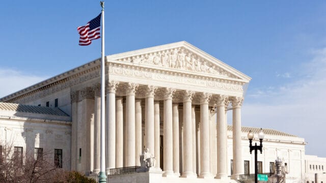 United States Supreme Court building with the American flag flying in front